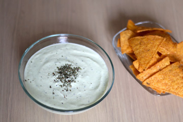 Bowl of broccoli, cheese and yoghurt dip and tortilla chips. Selective focus. 