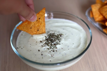 Bowl of broccoli, cheese and yoghurt dip and tortilla chips. Selective focus. 