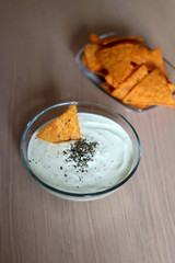 Bowl of broccoli, cheese and yoghurt dip and tortilla chips. Selective focus. 