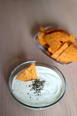 Bowl of broccoli, cheese and yoghurt dip and tortilla chips. Selective focus. 