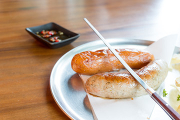 Grilled sausages with with potato chips on wooden background