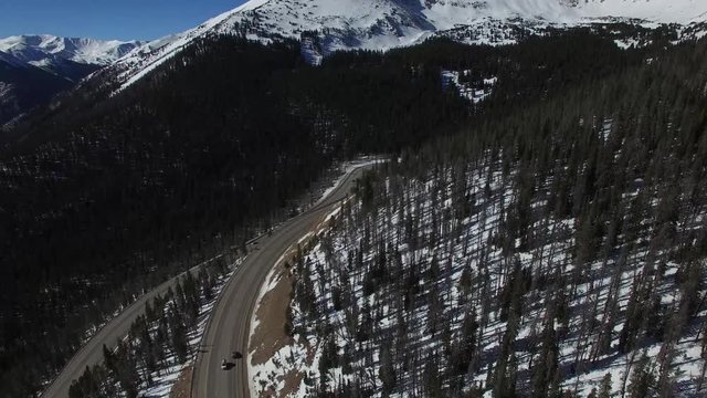 Aerial drone footage of Colorado highway over  Berthoud Pass and Continental Divide (tilt down)