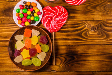 Different sweet candies on a wooden table. Top view