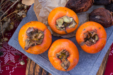 Orange sweet persimmon fruits on table. Fresh and raw healthy dessert