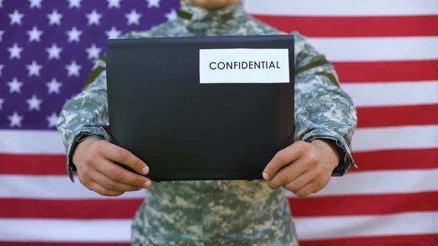 Soldier holding confidential folder in hands, secret agency information security