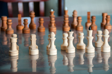 On table are wooden chess white and brown.