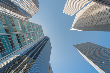 Upward view of skyscrapers against blue sky in the business district area of downtown Dallas, Texas, USA. - obrazy, fototapety, plakaty