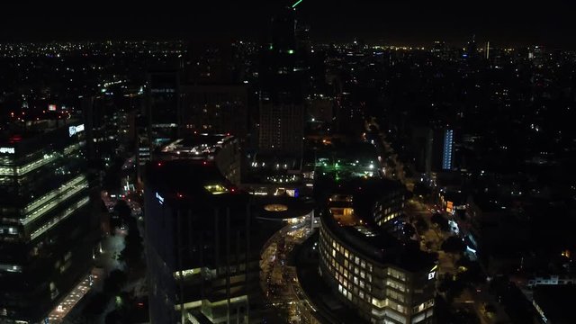 Aerial night panoramic view of Polanco district in Mexico City, drone asending and tilting down