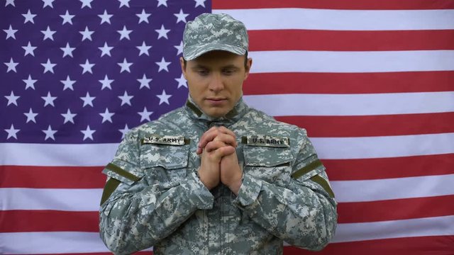 Enlisted male joining hands, praying for peace, american armed forces patriotism