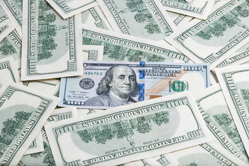 Background from dollars. Notes of one hundred American dollars are scattered across the background.