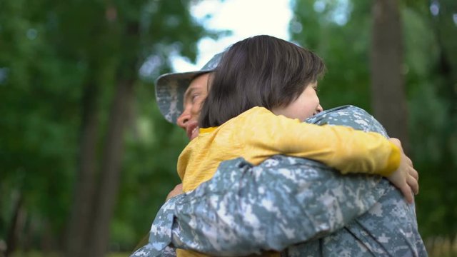 American sergeant giving high five and hugging son, soldier homecoming, family
