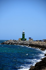 Starboard green lighthouse on a breakwater at the entrance to Freemantle harbour