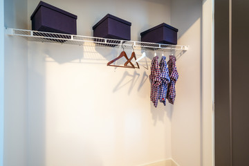 Boys closet with dress shirts and hangers.