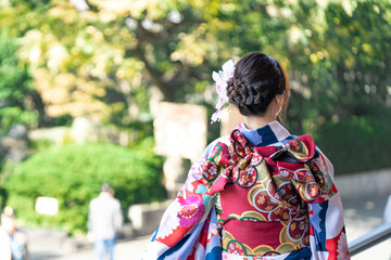 Fototapeta premium Young girl wearing Japanese kimono standing in front of Sensoji Temple in Tokyo, Japan. Kimono is a Japanese traditional garment. The word 