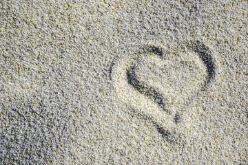 Small painted heart on white sand