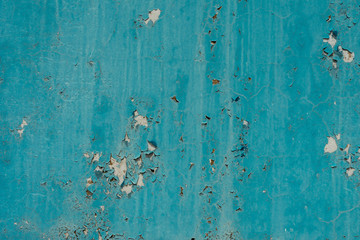 light coloured blue peeling paint on the old rough concrete surface