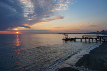 Amazing sunset on the ocean. View of dramatic cloudy sky and reflection of the sunlight on water.