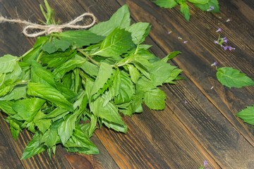 a bunch of fresh mint on a wooden background, a top view