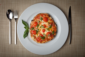 tomatoes pizza on a white plate