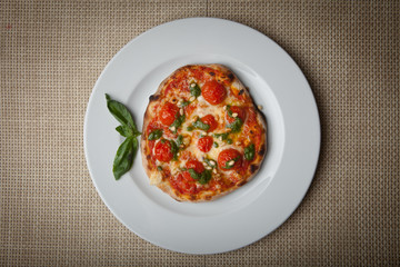 tomatoes pizza on a white plate