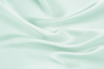 The texture of the satin fabric of green color for the background