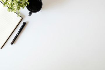 Copy space top view office desk coffee, pen and notebook with plant.