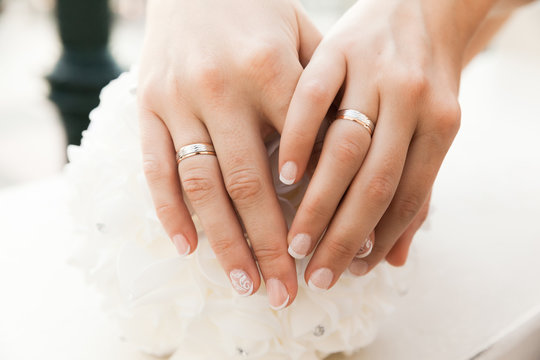 Closeup Of Hands With Wedding Rings Of Two Brides