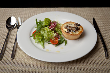 julienne in tartlet with salad and tomatoes on a white plate