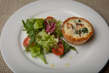 julienne in tartlet with salad and tomatoes on a white plate