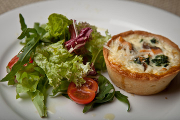 Fototapeta na wymiar julienne in tartlet with salad and tomatoes on a white plate