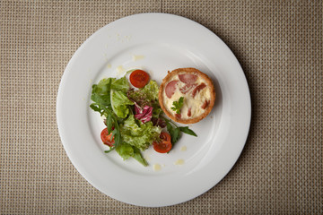 julienne in tartlet with salad and tomatoes on a white plate