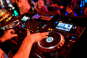 Dj mixes the track in the nightclub at party