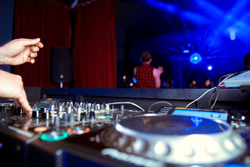 Dj mixes the track in the nightclub at party