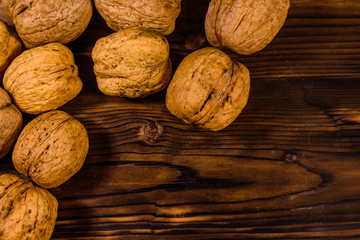 Pile of walnuts on a wooden table. Top view