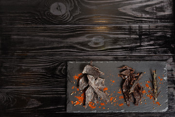Processed jerky on black stone board