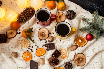 Fragrant coffee in bright cups on a handmade knitted rug. New Year celebration