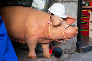 cerdo gracioso con un bozal y un casco y una bota de vino