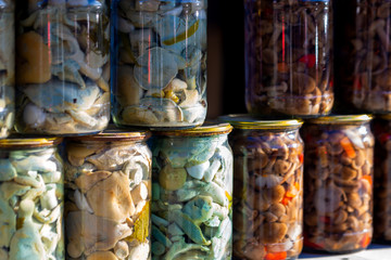 Pickled honey mushrooms in jars at village marketplace