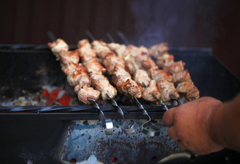 Meat And Vegetable Kebabs On The Hot BBQ Grill. Flaming Charcoal In The Background. Snack For Outdoor Summer Barbeque Party. Family dinner in the open air.