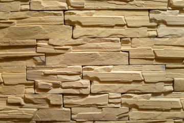 Close-up of an old stone wall with fragments of brick texture of natural stone, terracotta, beige