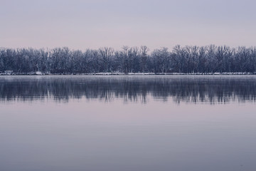 Winter landscape with river and forest.