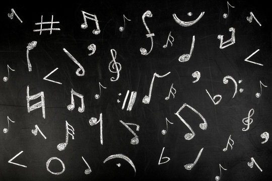 musical notes drawn in white chalk on a blackboard, background image