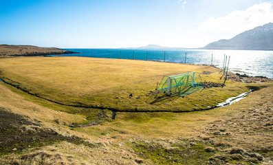 Naklejka premium The local football field nearly the coastal in East region of Iceland. Football is one of popular sport in this country.