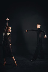 Beauty, fashion. Dancing over black background, beautiful couple of ballet dancers