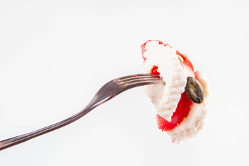 Caprese salad - tomato with mozzarella on a fork on a white background