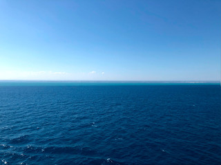 Andriatic Sea horizon line background. Backdrop of dark blue water and light clean blue sky on a summer morning. Cropped shot. Travel and cruise concept.