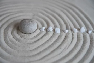 Foto auf Acrylglas Graue Zensteine auf dem Sand mit Wellenzeichnungen. Konzept der Harmonie, Balance und Meditation, Spa, Massage, Relax © strigana