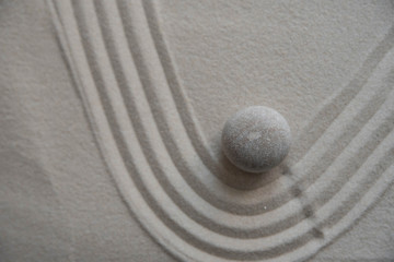 Gray zen stones on the sand with wave drawings. Concept of harmony, balance and meditation, spa, massage, relax