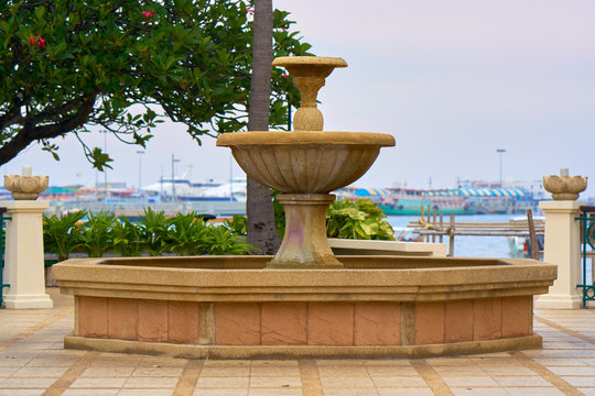 Empty fountain base on the ocean quay.