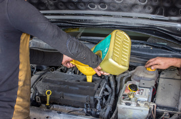the mechanic supplies oil to the car.